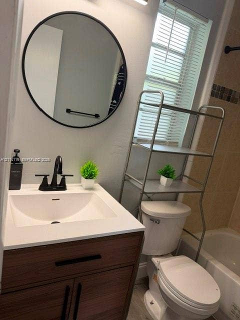Bathroom featuring a wood-finish vanity with a white countertop, undermount sink, matte black faucet, and circular wall-mounted mirror