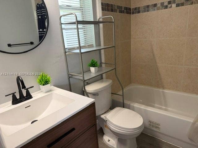 Bathroom featuring a vanity with a white rectangular sink, matte black faucet, and wood-finish cabinetry