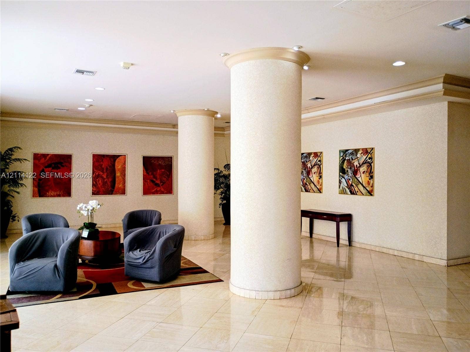 251 174th Street, #1208, Sunny Isles Beach, Sunny Isles Beach, FL 33160 Interior lobby featuring light-toned stone flooring, recessed ceiling lighting, crown molding, and prominent cylindrical structural columns