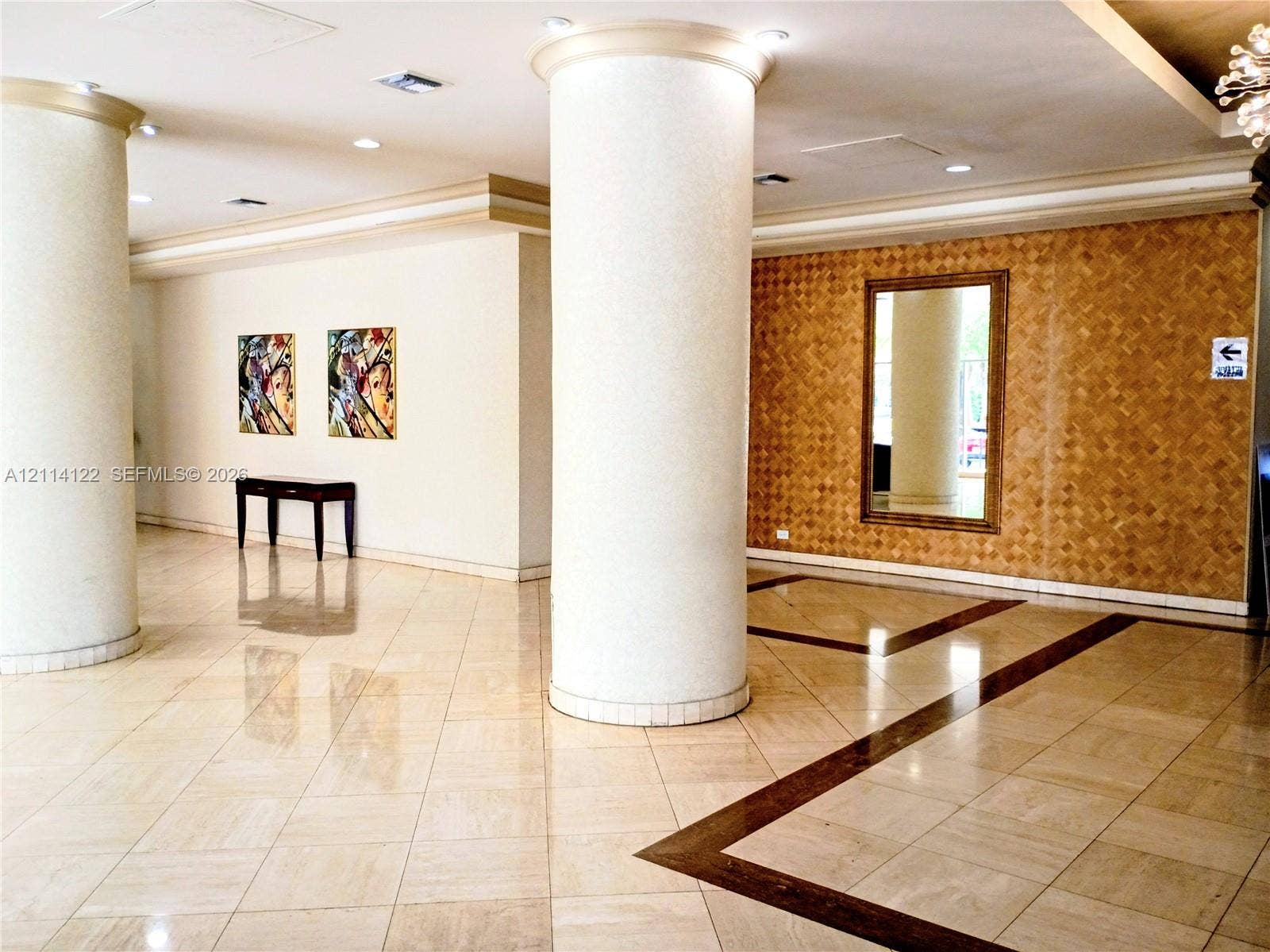 251 174th Street, #1208, Sunny Isles Beach, Sunny Isles Beach, FL 33160 Spacious foyer featuring large-scale cylindrical architectural columns, polished stone flooring with decorative inlay, recessed ceiling lighting, and a textured accent wall