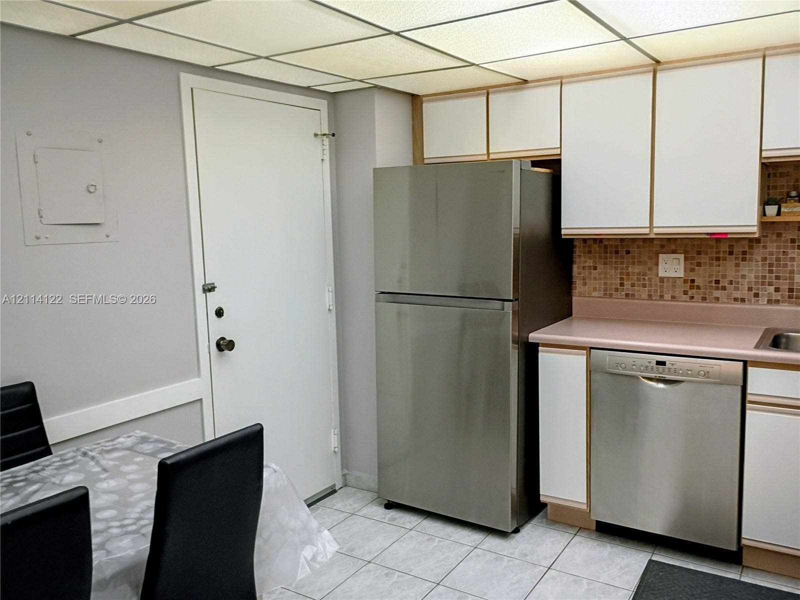 251 174th Street, #1208, Sunny Isles Beach, Sunny Isles Beach, FL 33160 Kitchen area featuring stainless steel refrigerator and dishwasher, tiled backsplash, cabinetry with white finish, and tile flooring