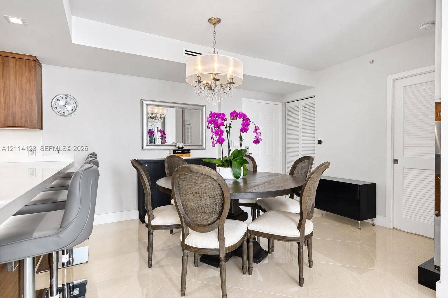 1155 Brickell Bay Drive, #2609, Miami, FL 33131 Dining space featuring a multi-tiered crystal chandelier, polished neutral tile flooring, and white recessed lighting