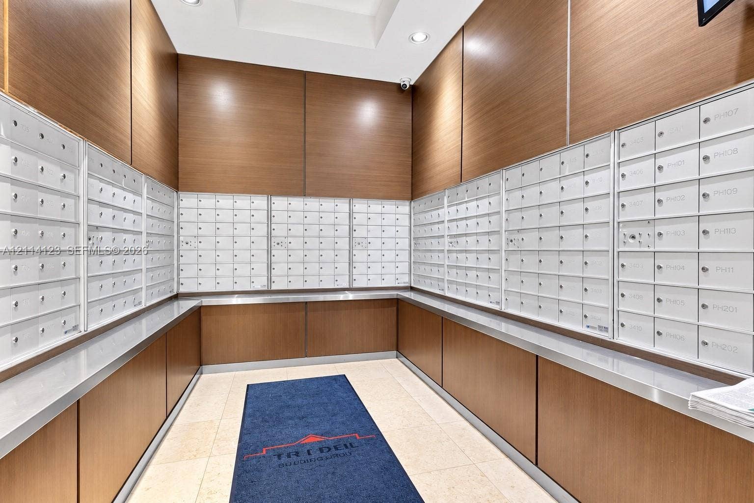 1155 Brickell Bay Drive, #2609, Miami, FL 33131 Mail center featuring floor-to-ceiling wood-finish paneling, white metal parcel boxes, recessed lighting, and stone flooring
