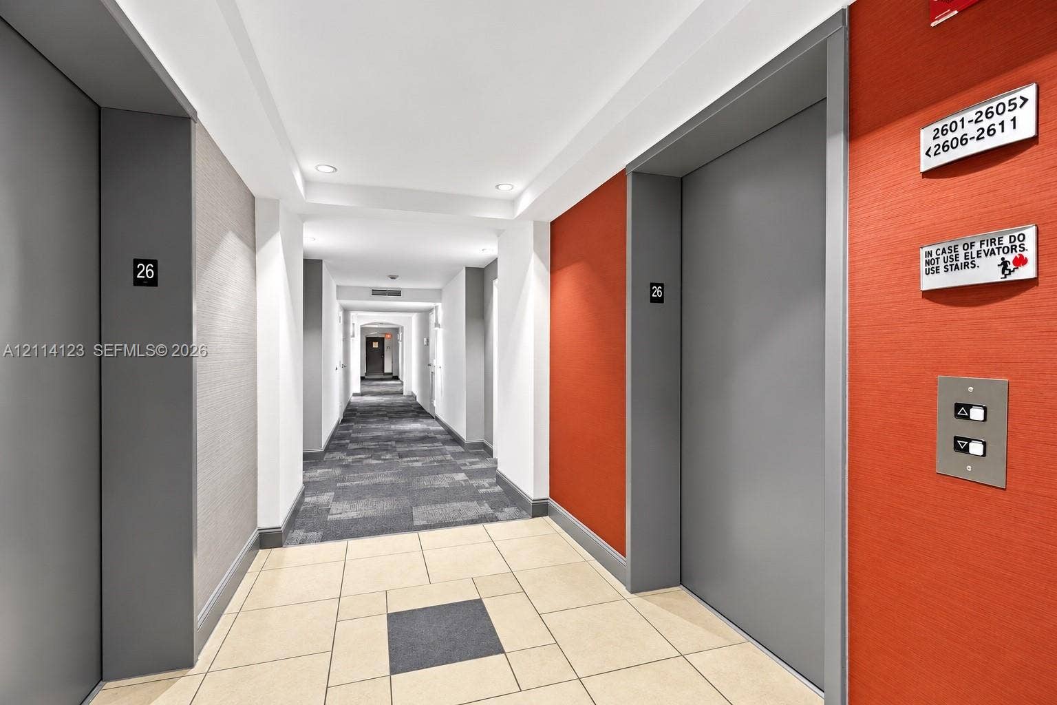 1155 Brickell Bay Drive, #2609, Miami, FL 33131 Elevator lobby featuring metallic-finish doors, textured wall treatments, integrated recessed lighting, and large-format ceramic tile flooring