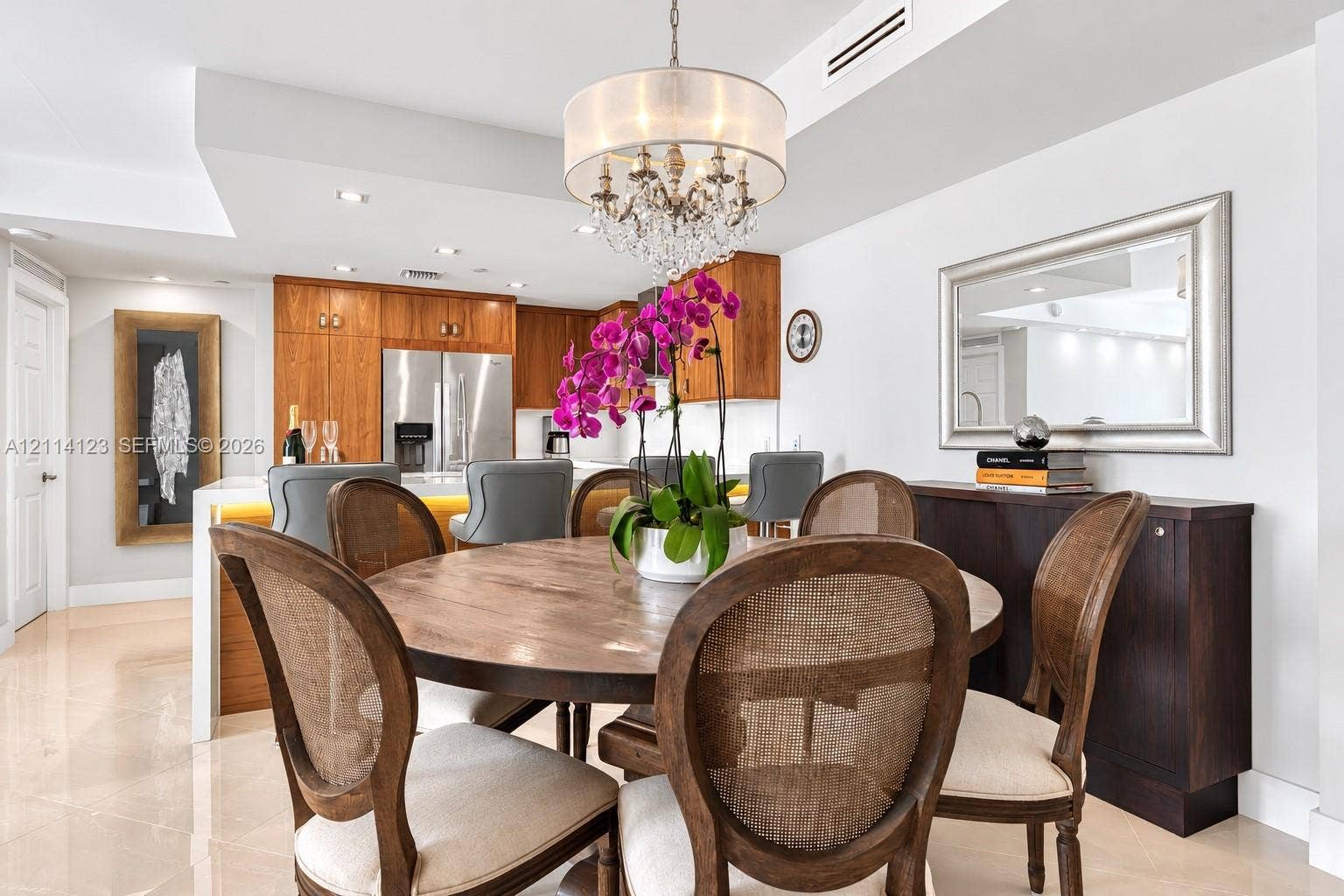1155 Brickell Bay Drive, #2609, Miami, FL 33131 Dining area featuring polished tile flooring, a crystal chandelier, and a built-in kitchen peninsula with illuminated base cabinetry