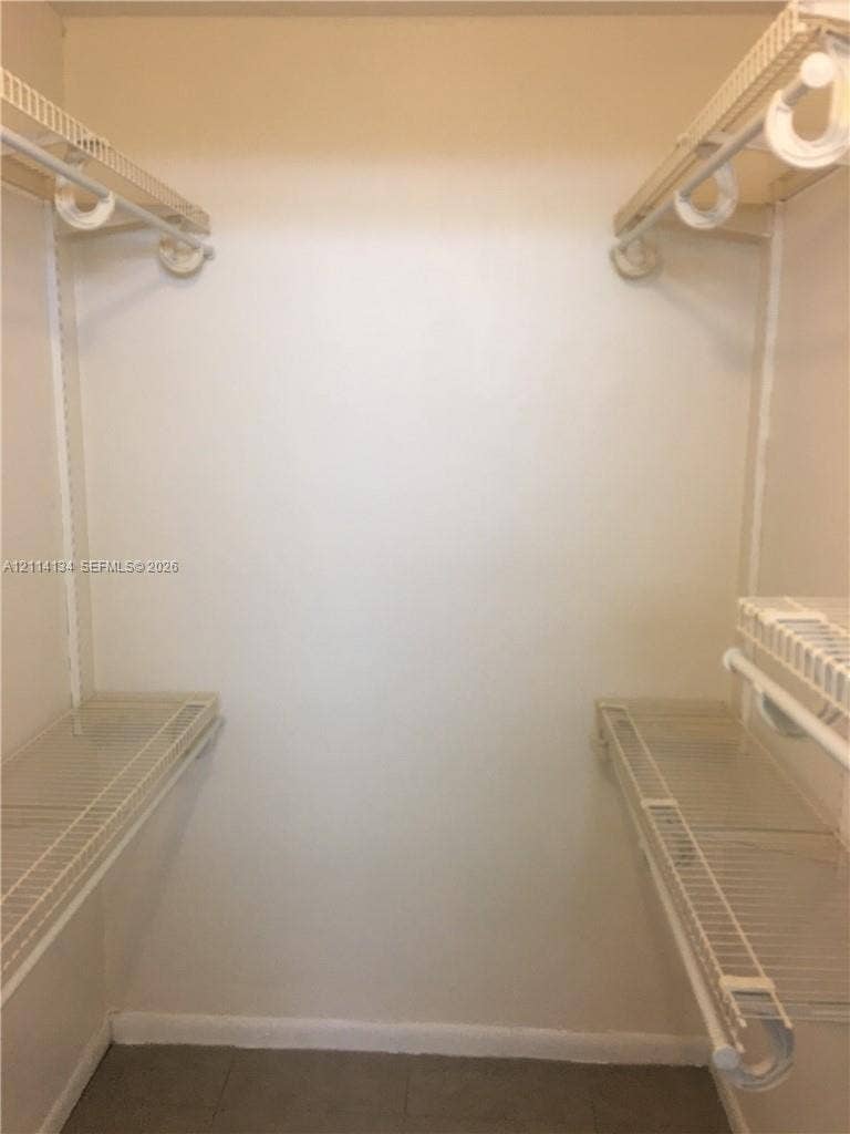 12143 Royal Palm Boulevard, #8E, Coral Springs, Coral Springs, FL 33065 Walk-in storage space featuring dual-level white wire shelving and integrated hanging rods