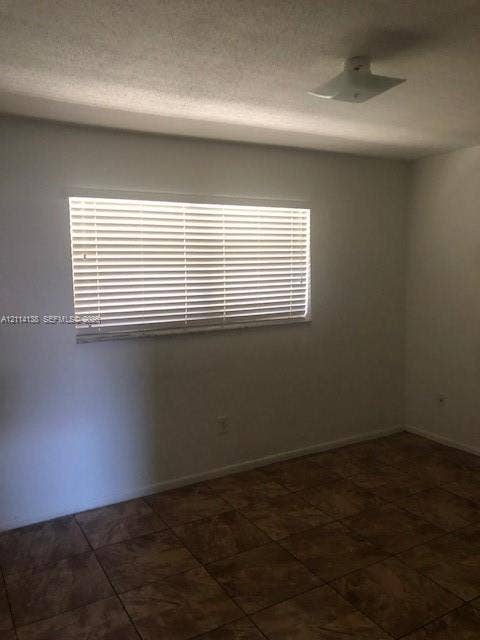 2323 Scott Street, #Front, Hollywood, Hollywood, FL 33020 Interior room featuring neutral wall finishes, tile flooring, horizontal window blinds, and a flush-mount ceiling light fixture