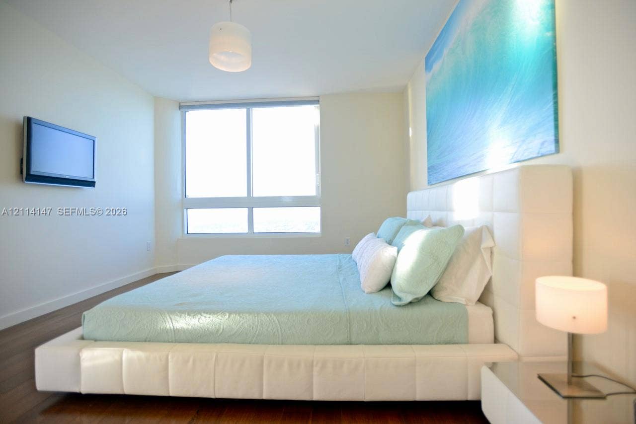 6365 Collins Avenue, #3908, Miami Beach, FL 33141 Wood-finish flooring, floor-to-ceiling windows, and wall-mounted television