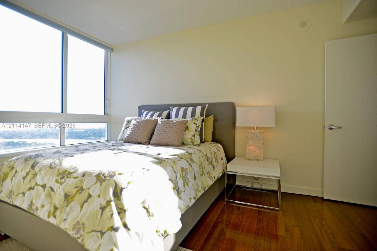 6365 Collins Avenue, #3908, Miami Beach, FL 33141 Floor-to-ceiling windows, wood-finish flooring, and neutral painted walls