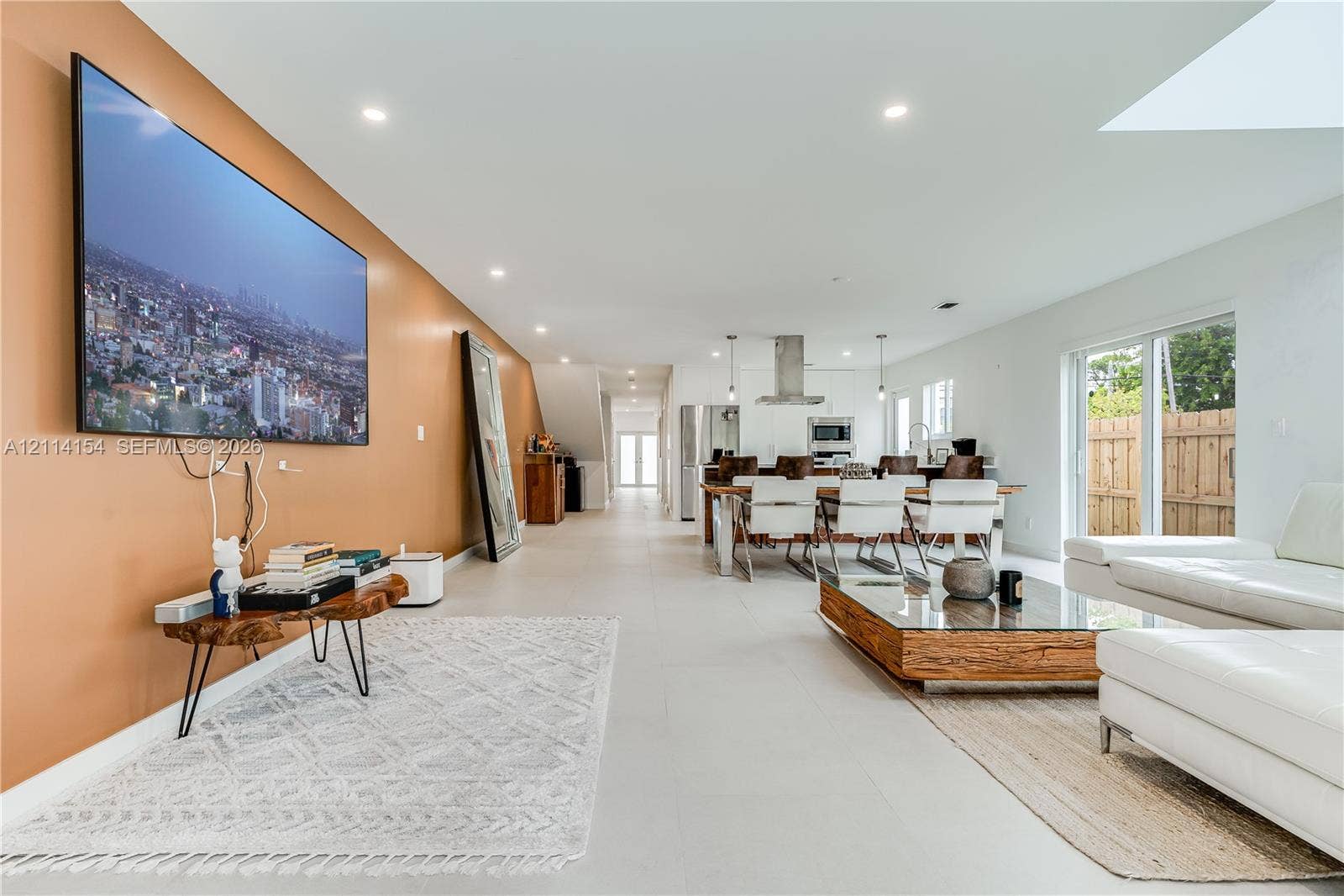 1126 NE 2nd Avenue, Fort Lauderdale, FL 33304 Open-concept interior featuring large-format tile flooring, recessed lighting, a stainless steel kitchen range hood, and sliding glass doors
