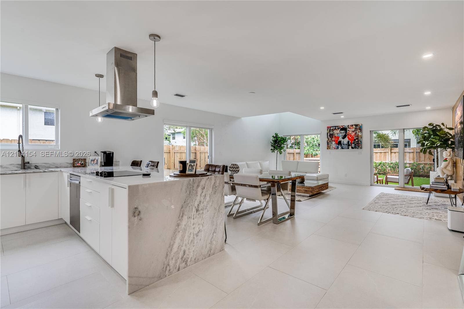 1126 NE 2nd Avenue, Fort Lauderdale, FL 33304 Kitchen featuring white cabinetry, stone-surface waterfall island, stainless steel range hood, and large-format tile flooring
