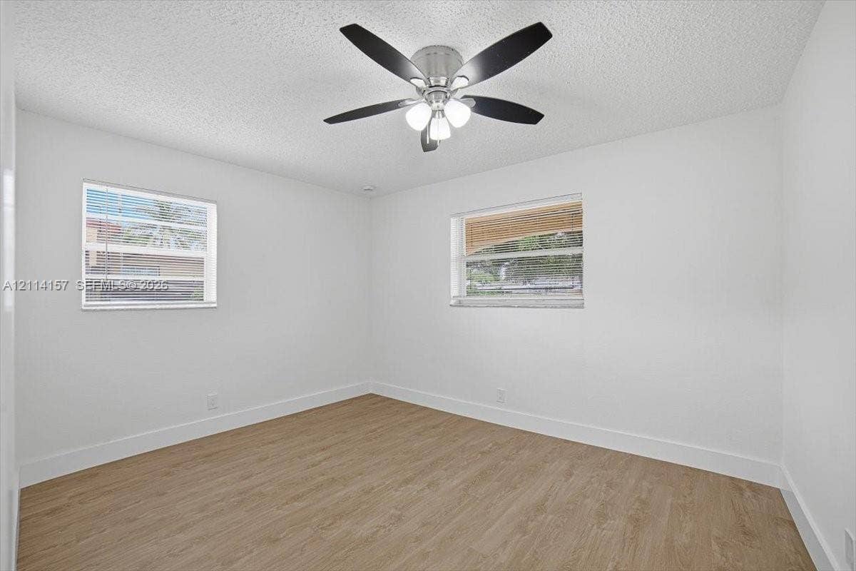 2580 NW 62nd Avenue, Margate, FL 33063 Wood-finish flooring, white walls, dual windows, and a multi-blade ceiling fan with integrated lighting