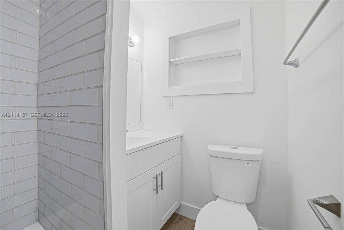 2580 NW 62nd Avenue, Margate, FL 33063 Bathroom featuring subway tile shower surround, white vanity with integrated basin, recessed wall niche, and polished chrome hardware