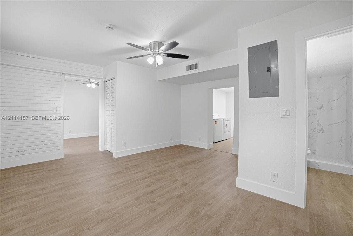 2580 NW 62nd Avenue, Margate, FL 33063 Wood-finish flooring, horizontal shiplap wall detail, ceiling fan with integrated lighting, and louvered closet doors