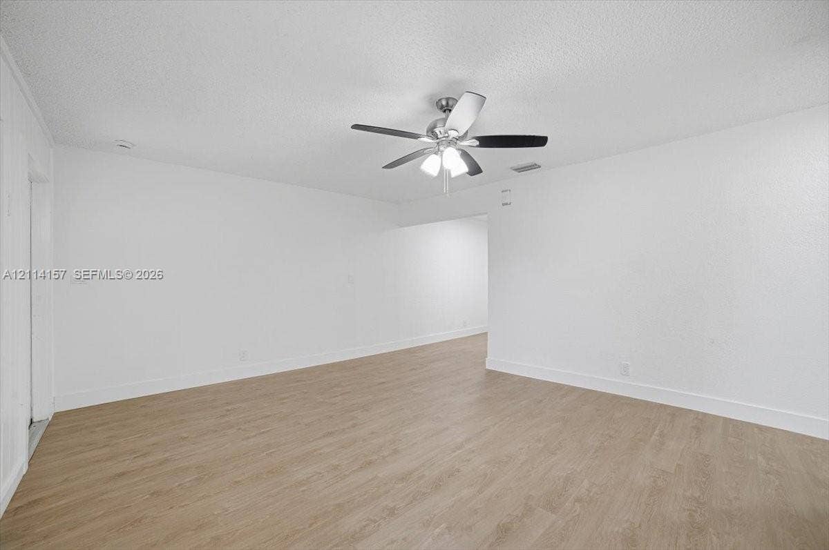 2580 NW 62nd Avenue, Margate, FL 33063 Interior space featuring wood-finish flooring, white walls, and a ceiling fan with integrated lighting