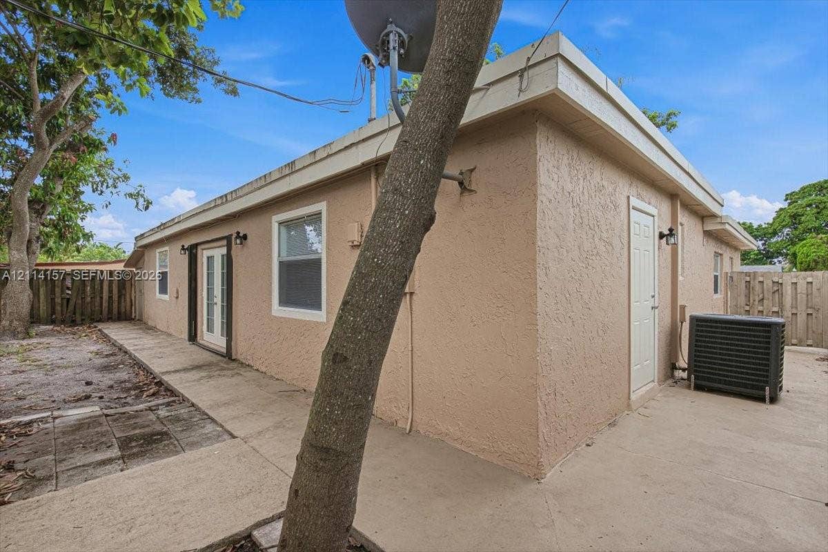 2580 NW 62nd Avenue, Margate, FL 33063 Stucco exterior featuring dual-entry doors, concrete side patio, and wood privacy fencing