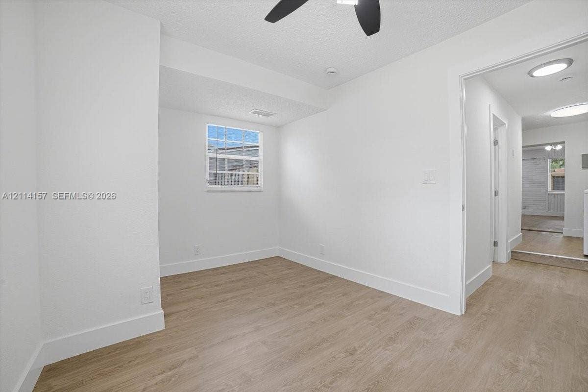 2580 NW 62nd Avenue, Margate, FL 33063 Room featuring wood-finish flooring, a grid-pane window, and a multi-blade ceiling fan