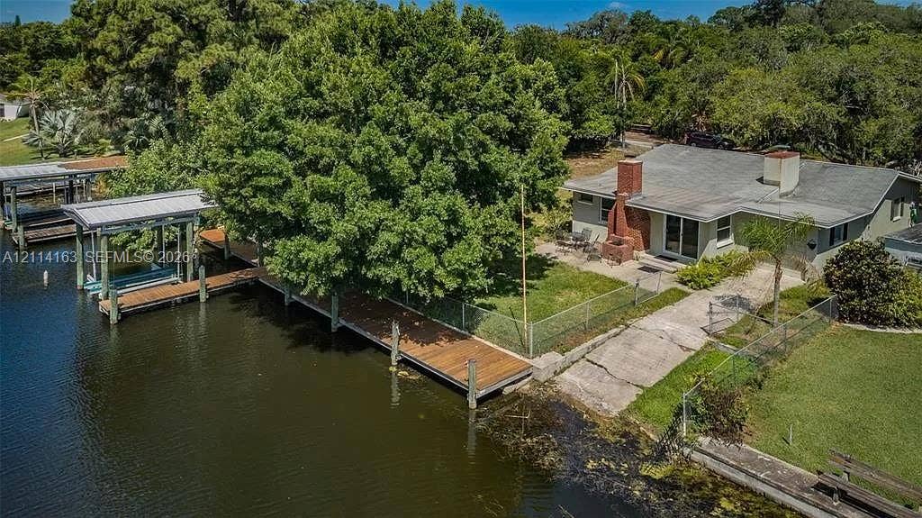 Back of home featuring boat ramp, dock, lift