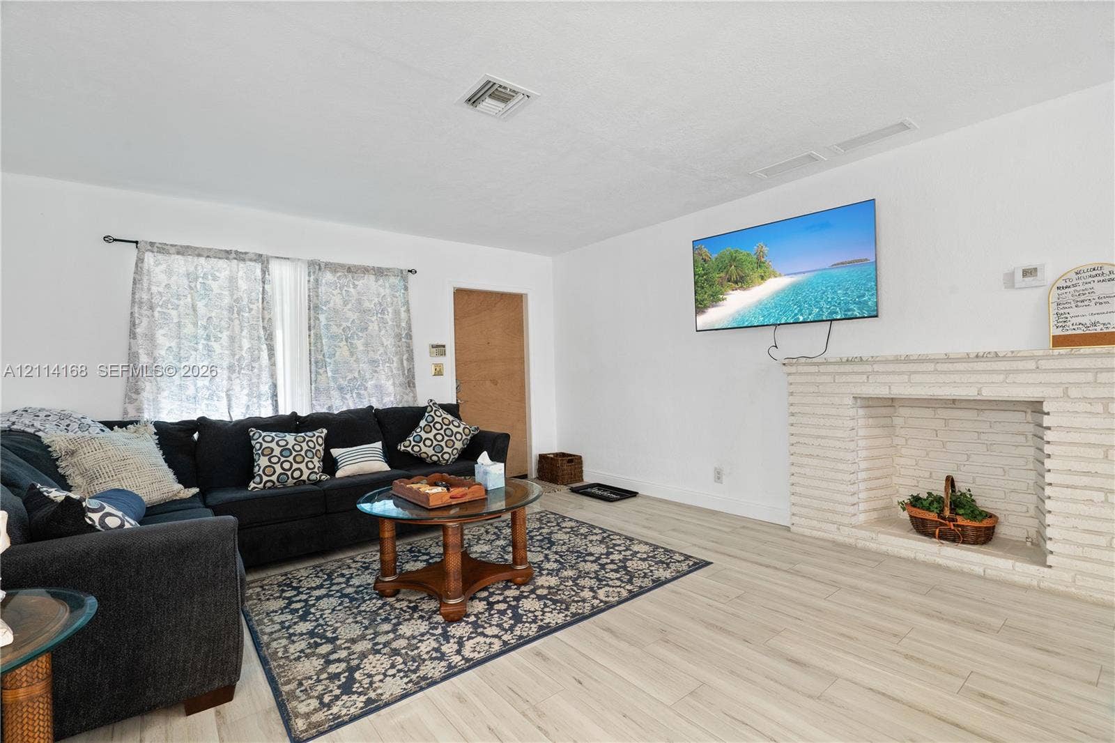 Living area featuring Italian Tile flooring and a white-painted brick fireplace with a stone mantel