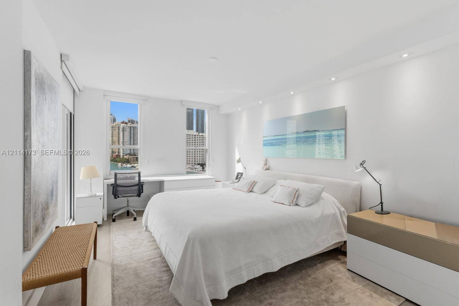 701 Brickell Key Boulevard, #1012, Miami, FL 33131 Interior space featuring recessed ceiling lighting, light-toned flooring, and built-in desk cabinetry beneath vertical windows with urban exterior surroundings
