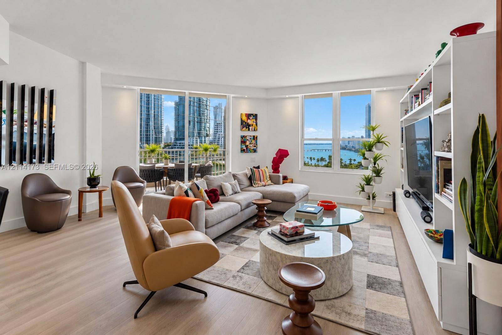 701 Brickell Key Boulevard, #1012, Miami, FL 33131 Living area featuring floor-to-ceiling windows, wood-finish flooring, built-in shelving, and a balcony