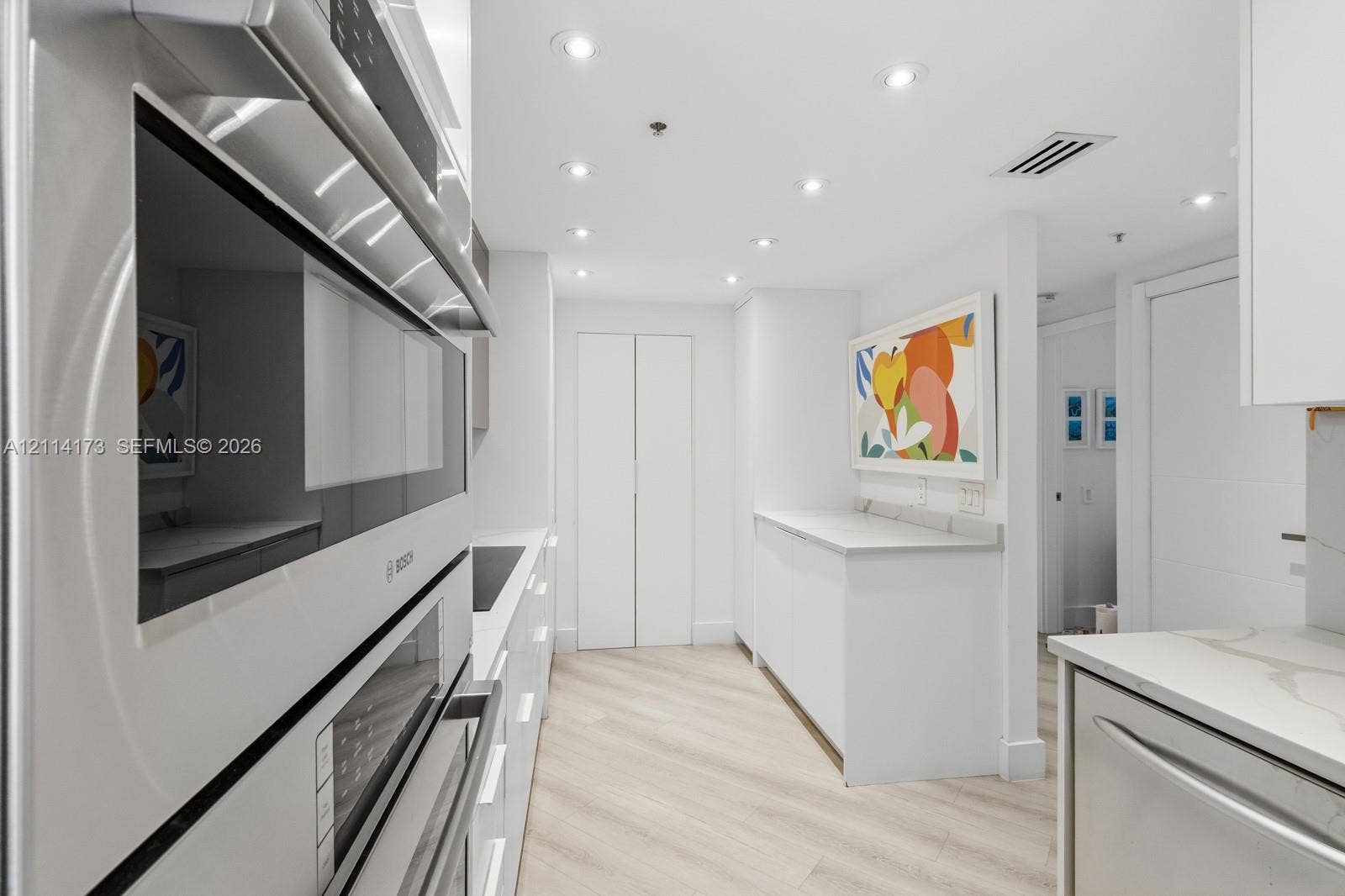701 Brickell Key Boulevard, #1012, Miami, FL 33131 Kitchen featuring integrated wall ovens, white cabinetry, solid surface countertops, recessed lighting, and wood-finish flooring
