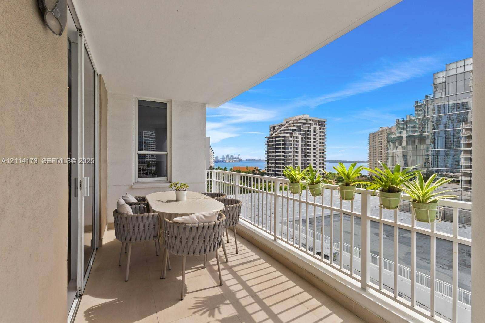 701 Brickell Key Boulevard, #1012, Miami, FL 33131 Covered balcony with neutral tile flooring, white metal railing, and sliding glass door access