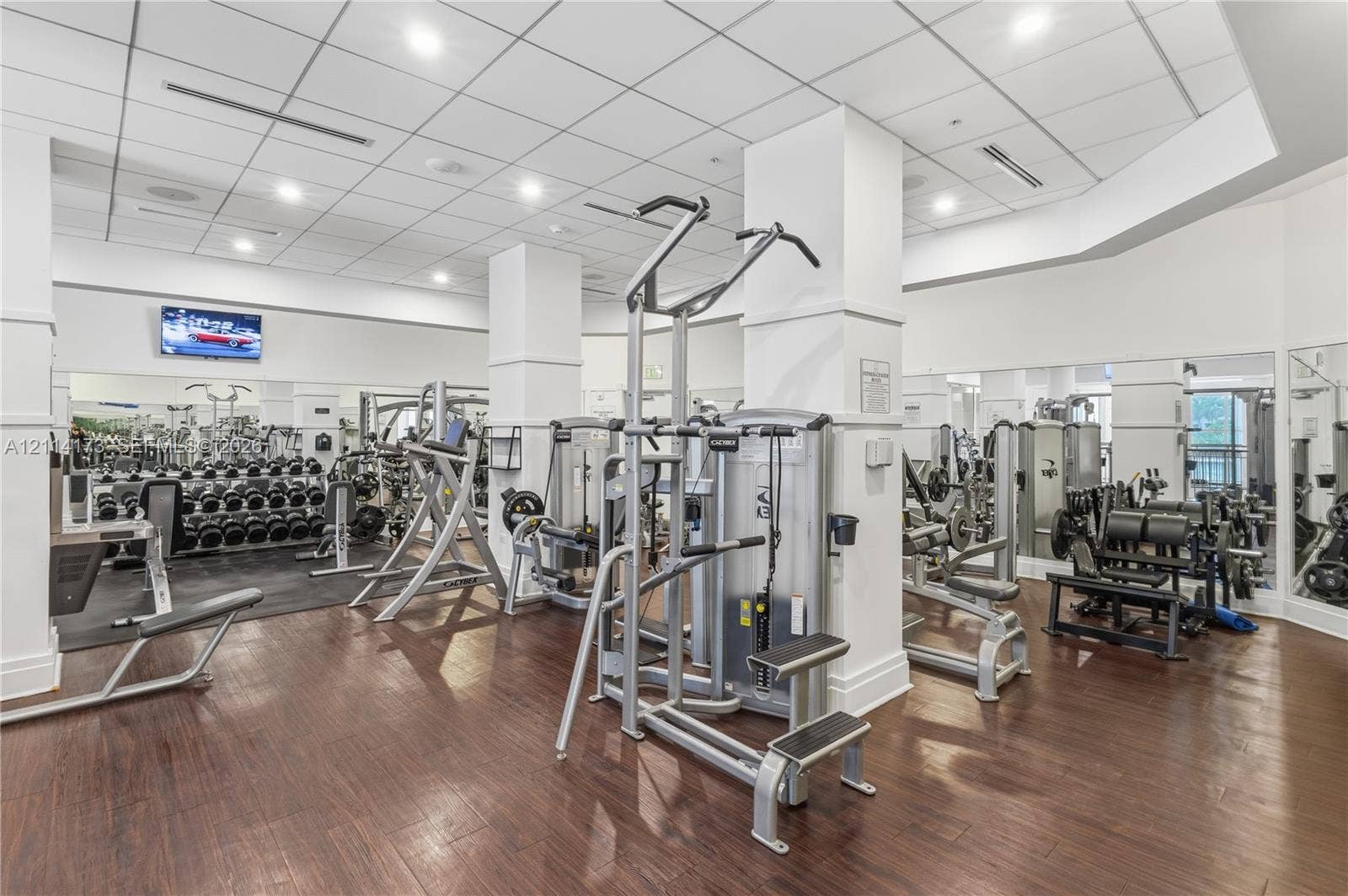 701 Brickell Key Boulevard, #1012, Miami, FL 33131 Fitness center featuring wood-finish flooring, recessed lighting, drop ceiling panels, and full-length wall mirrors