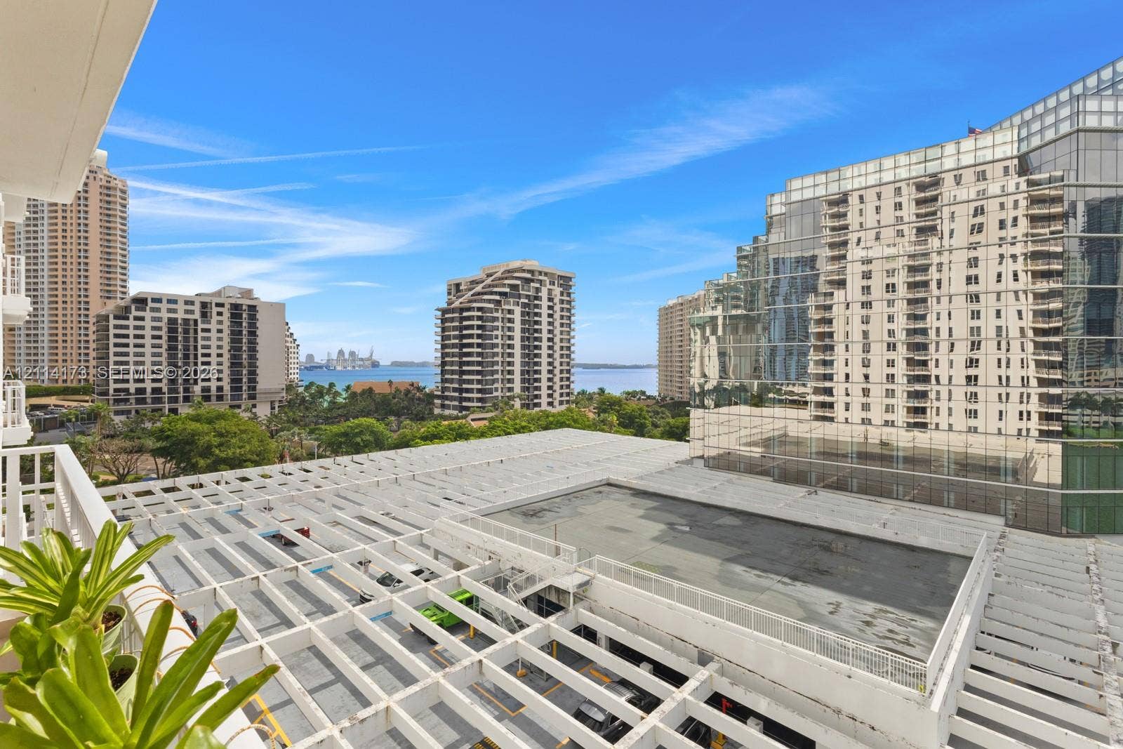 701 Brickell Key Boulevard, #1012, Miami, FL 33131 Private balcony featuring a structural white trellis overhead and a perspective of the surrounding urban skyline, waterfront, and marina
