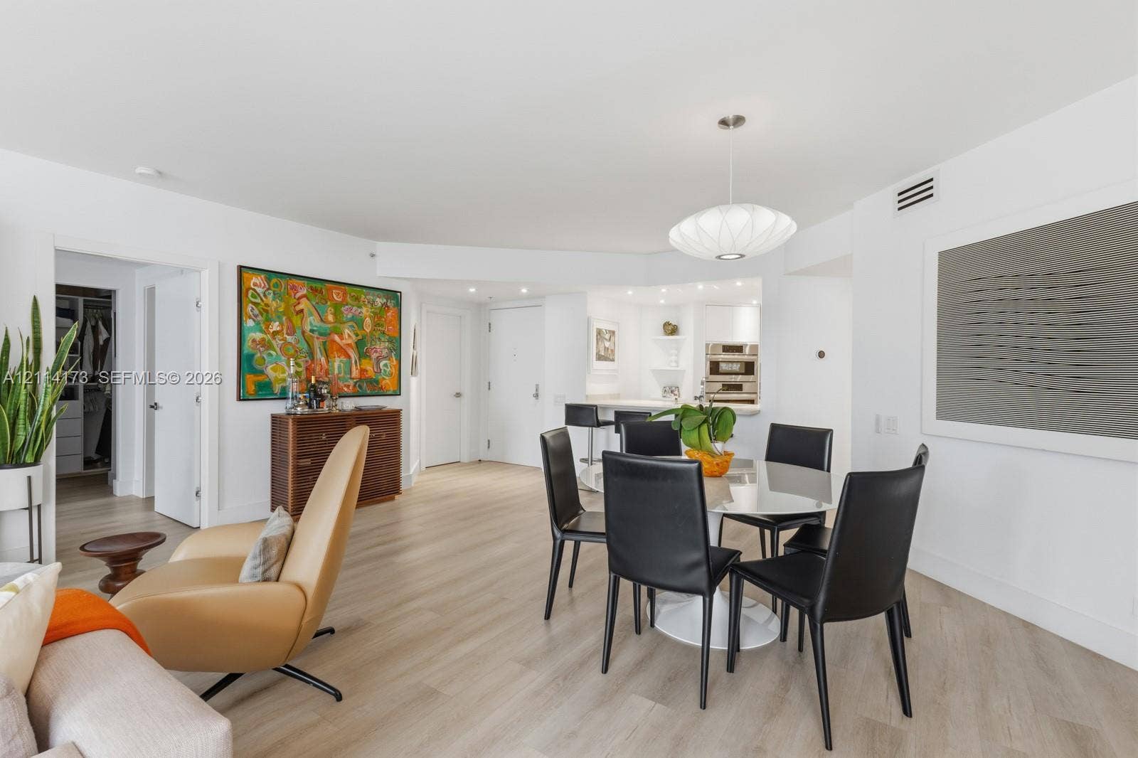 701 Brickell Key Boulevard, #1012, Miami, FL 33131 Open-concept interior featuring light-toned wood-finish flooring, recessed lighting, and a modern pendant fixture