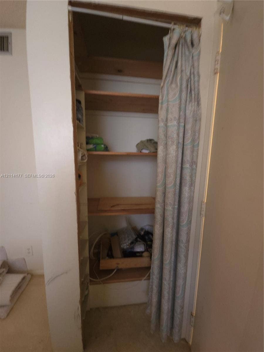 1731 SE 15th Street, #403, Fort Lauderdale, FL 33316 Storage alcove featuring built-in wooden shelving and tiered side shelving units