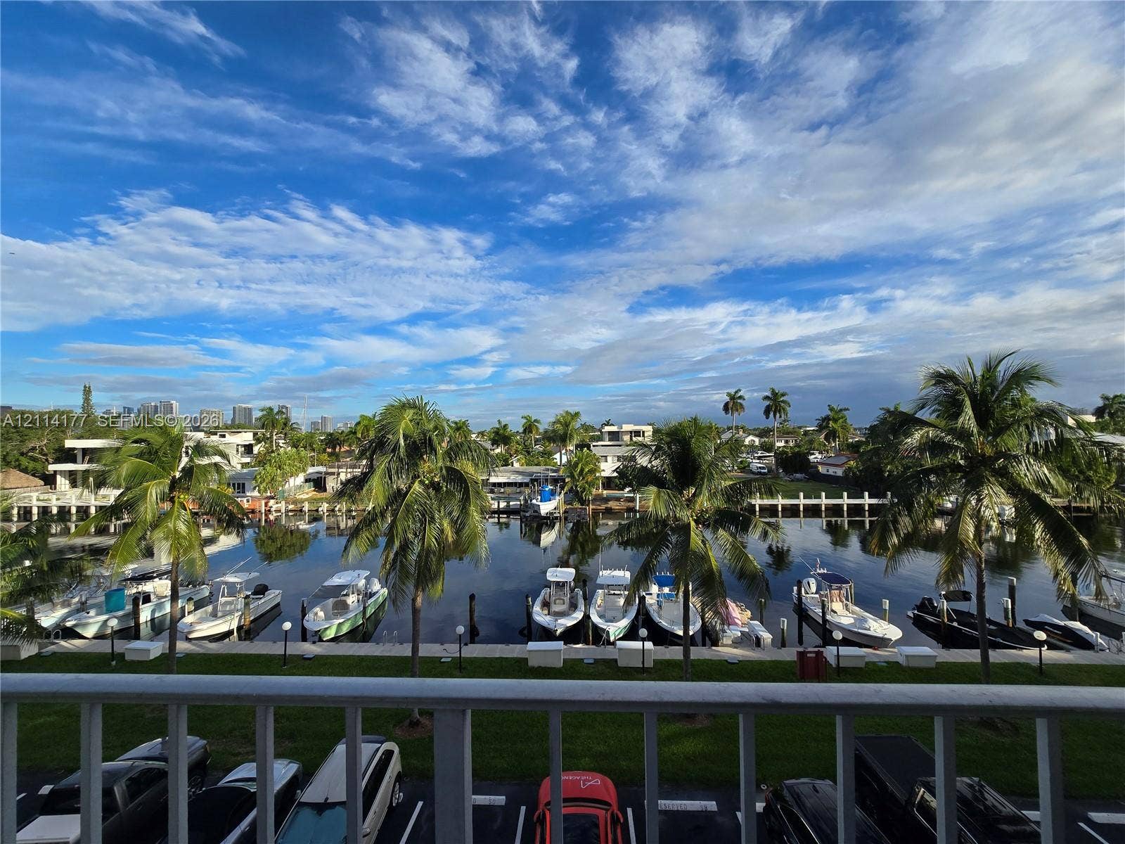 1731 SE 15th Street, #403, Fort Lauderdale, FL 33316 Waterfront scenery featuring a bulkhead, concrete dockage, mature palm trees, and a paved parking area