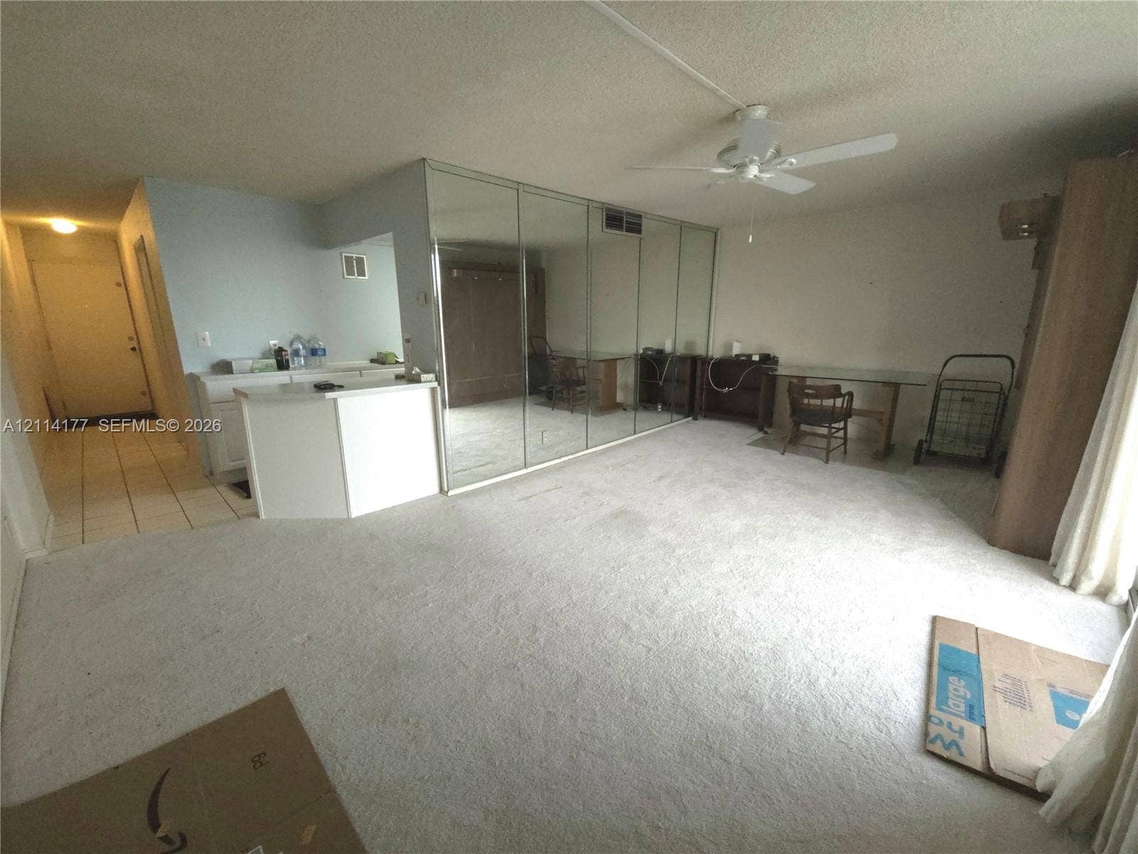 1731 SE 15th Street, #403, Fort Lauderdale, FL 33316 Spacious interior featuring full-wall mirrored closet doors, white built-in cabinetry, ceiling fan, and tile flooring in the entry area