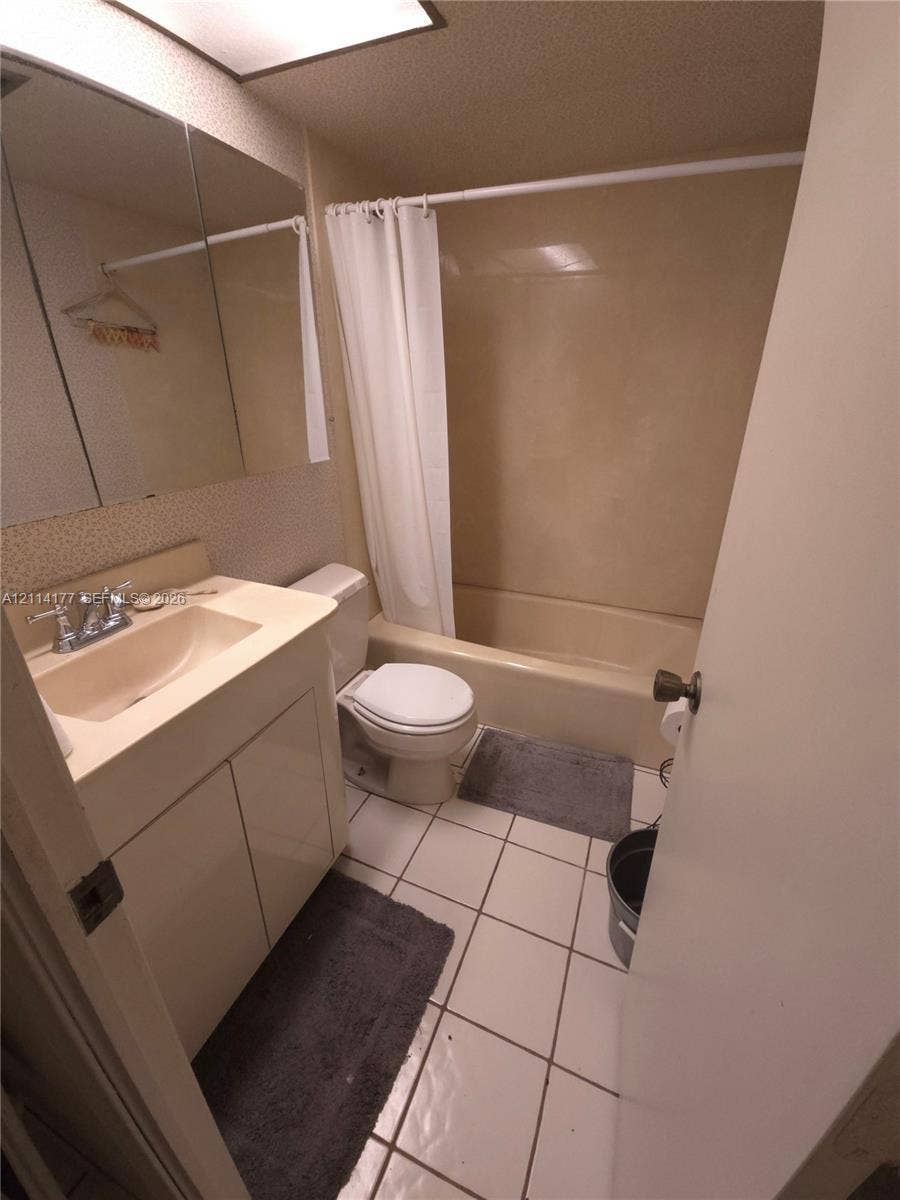 1731 SE 15th Street, #403, Fort Lauderdale, FL 33316 Bathroom featuring a single-sink vanity with integrated basin, medicine cabinet, tiled flooring, and a combined tub and shower enclosure