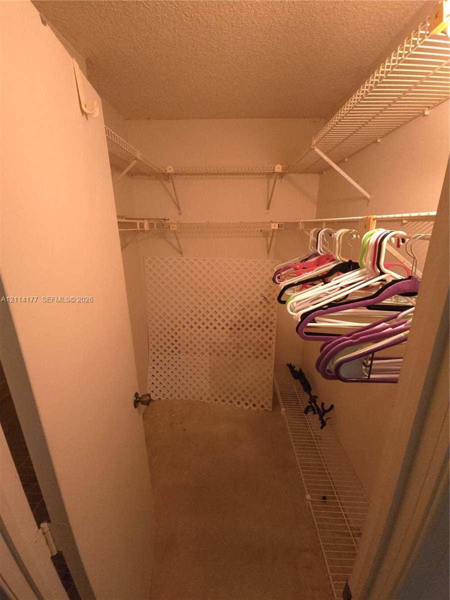 1731 SE 15th Street, #403, Fort Lauderdale, FL 33316 Walk-in closet featuring tiered white wire shelving and a floor-level lattice storage partition
