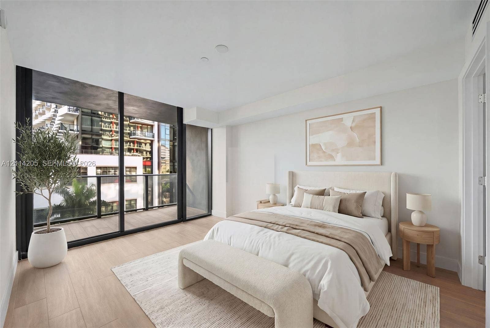 Floor-to-ceiling glass sliding doors, wood-finish flooring, and a private balcony with black metal railings - staged