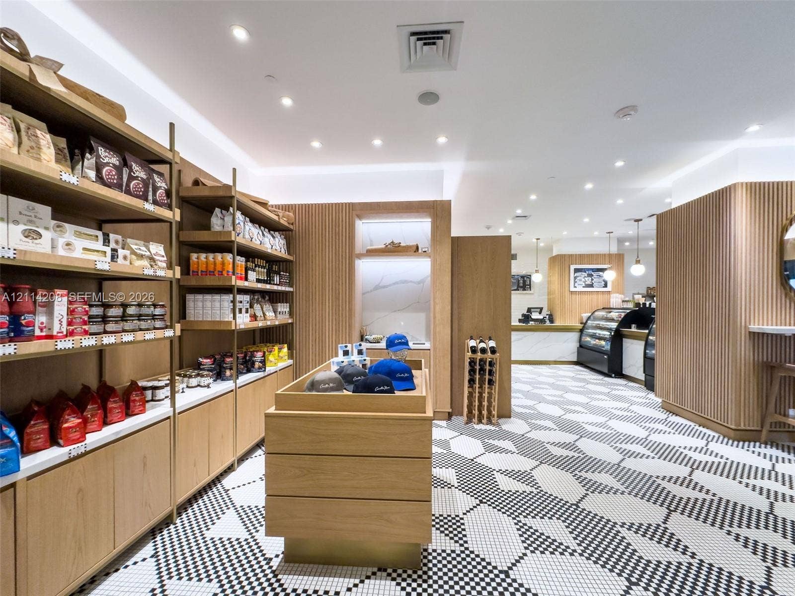 6801 Collins Avenue, #604, Miami Beach, FL 33141 Commercial space featuring geometric patterned tile flooring, custom wood-slat wall paneling, open shelving with integrated lighting, and stone-surfaced service counters