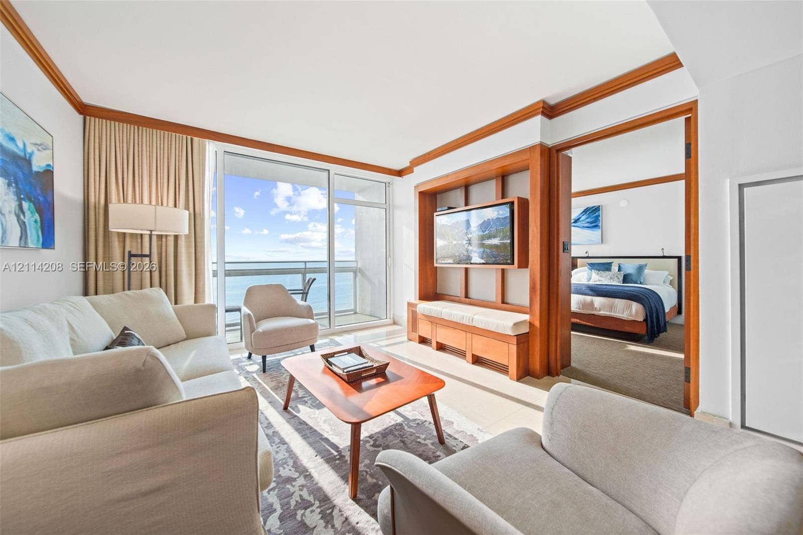 6801 Collins Avenue, #604, Miami Beach, FL 33141 F a balcony, custom wood-trim media center with built-in cabinetry, and crown molding