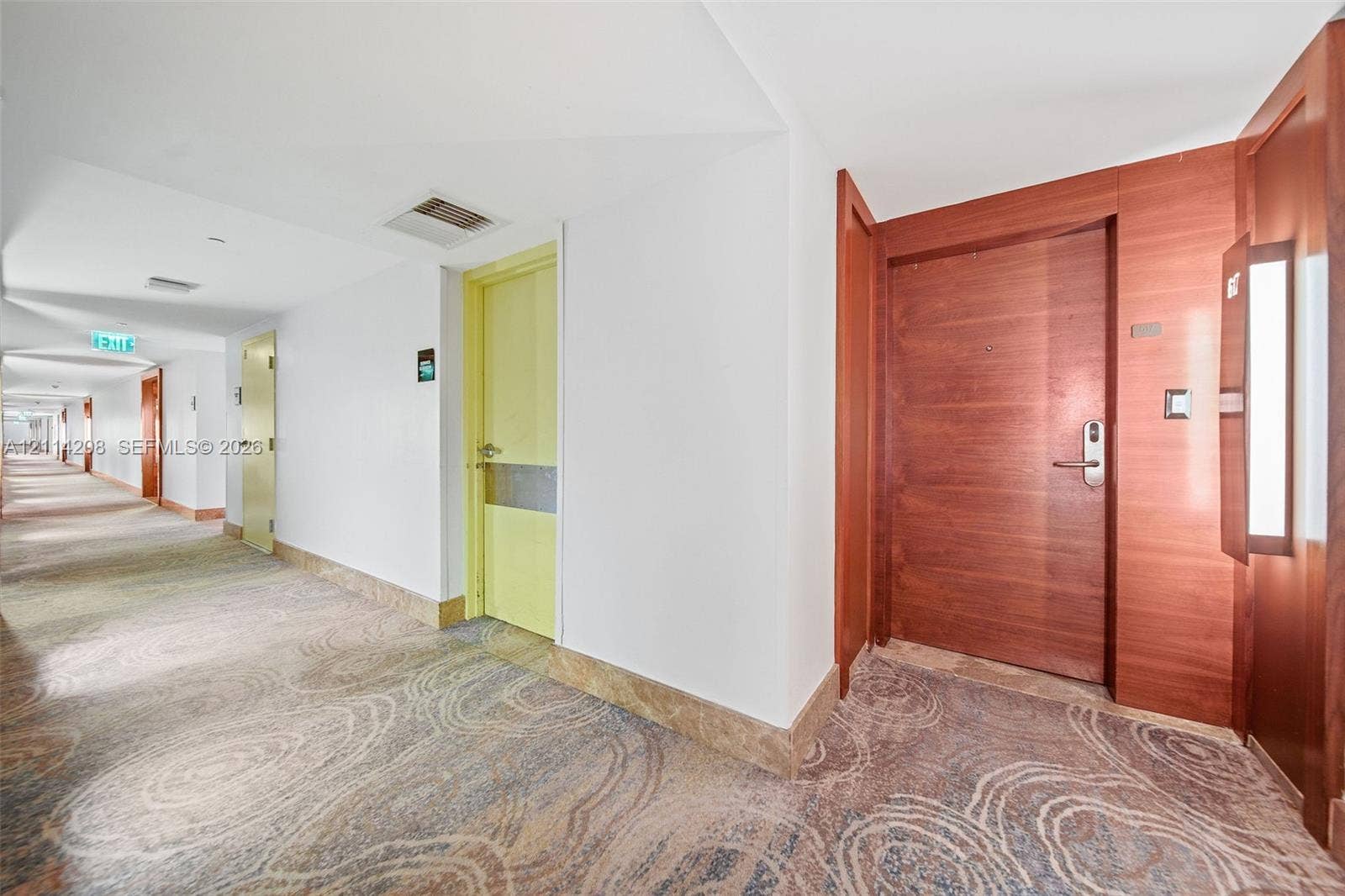 6801 Collins Avenue, #604, Miami Beach, FL 33141 Hallway featuring pattern-carpeted flooring, solid wood-finish entry door with electronic deadbolt, smooth walls, and recessed lighting