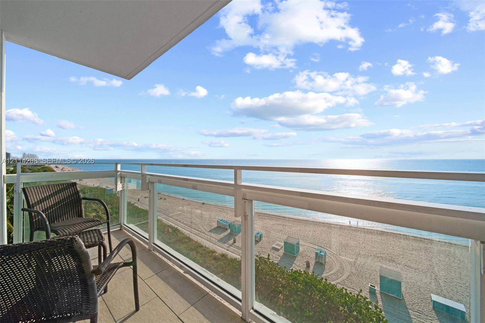 6801 Collins Avenue, #604, Miami Beach, FL 33141 Private balcony featuring oversized tile flooring and a glass-panel railing overlooking the coastline