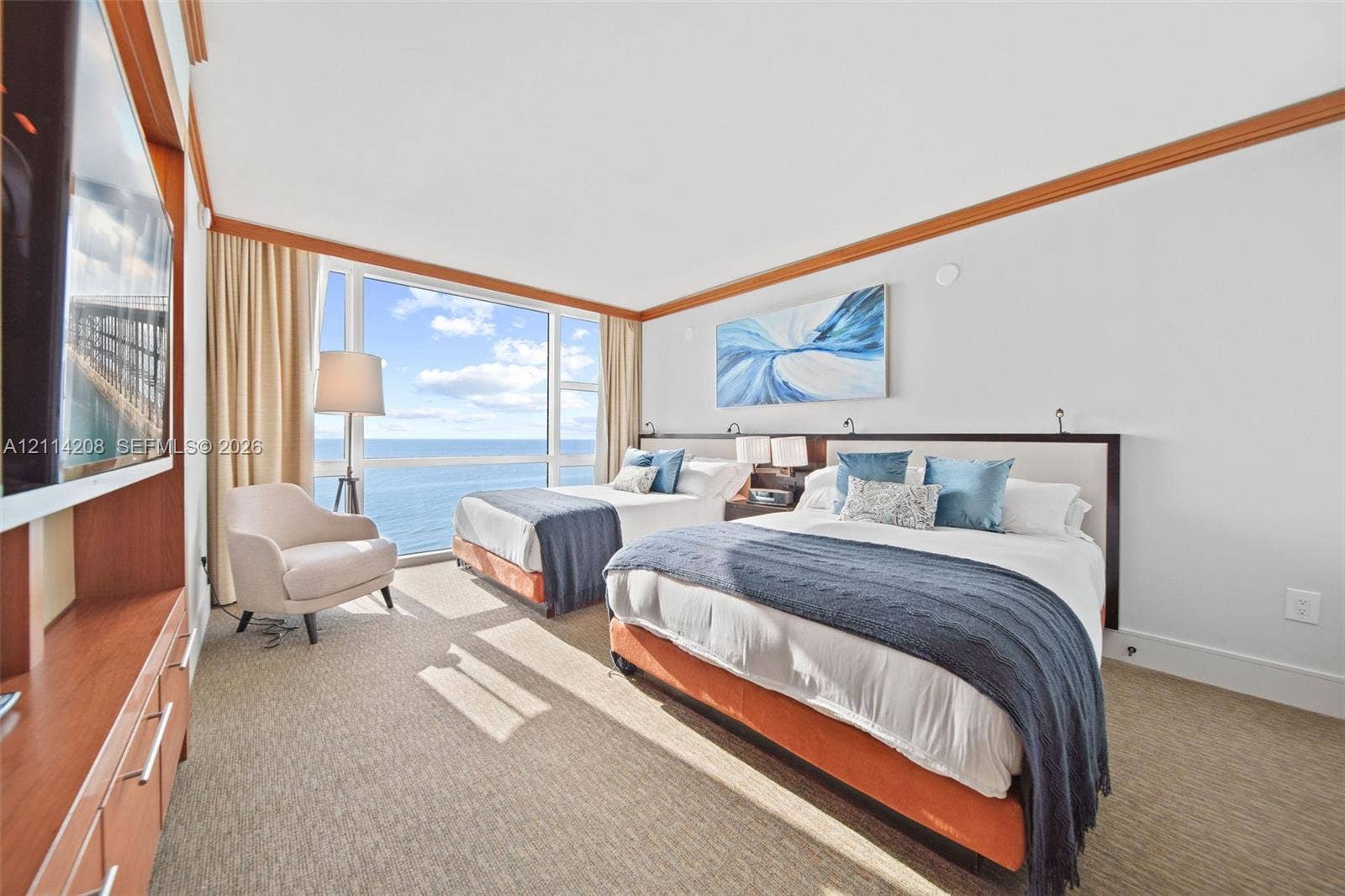 6801 Collins Avenue, #604, Miami Beach, FL 33141 Floor-to-ceiling windows, ocean horizon, built-in wooden cabinetry, crown molding, and neutral wall-to-wall carpeting