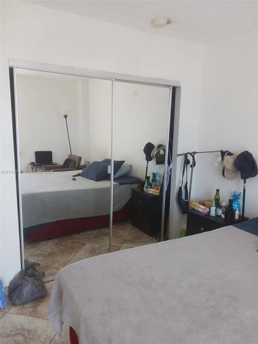 3701 N Country Club Drive, #706, Aventura, FL 33180 Sliding bypass closet doors with floor-to-ceiling mirrored panels and stone-finish tile flooring