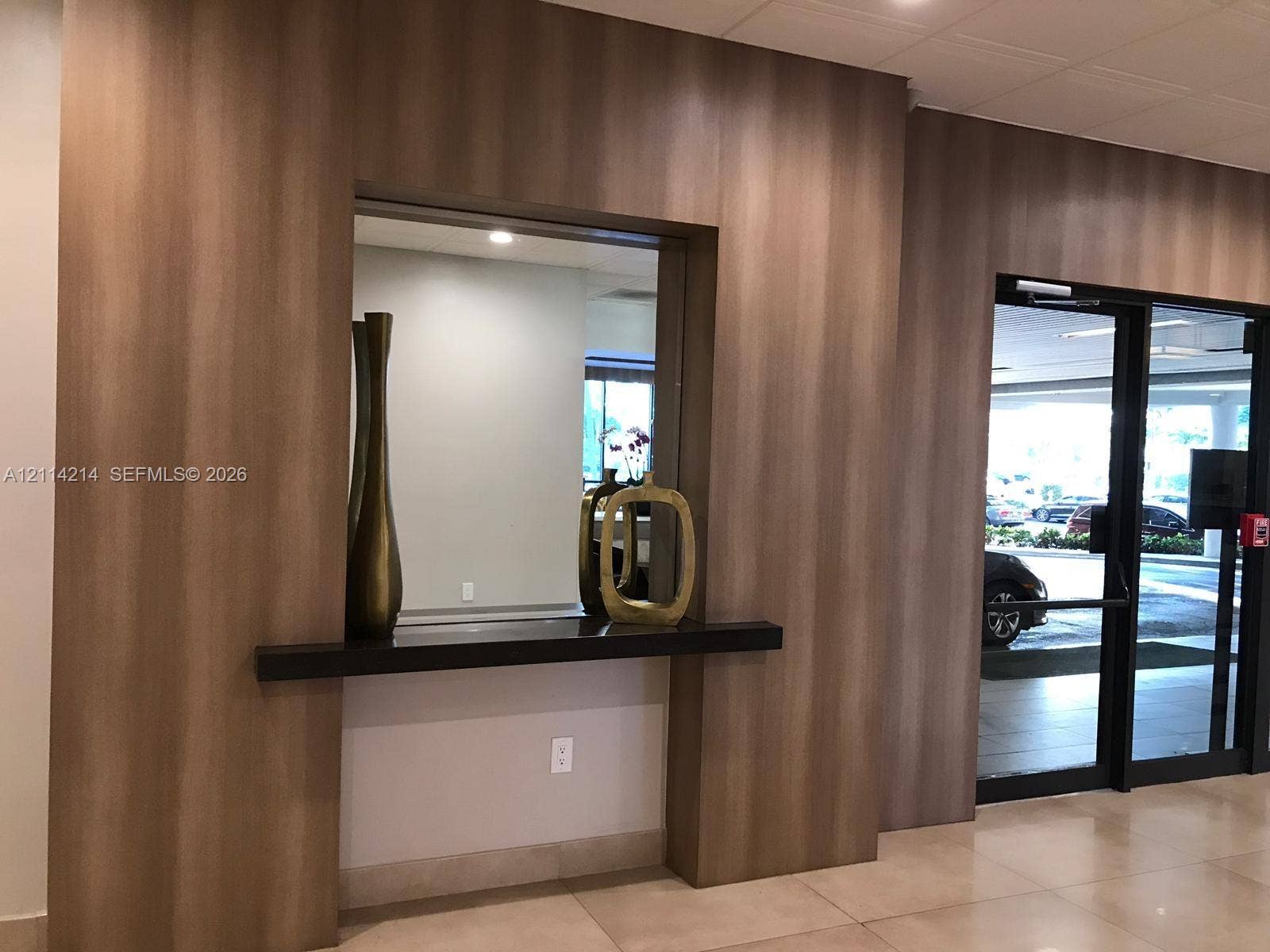 3701 N Country Club Drive, #706, Aventura, FL 33180 Wood-finish paneling, built-in shelving, glass-paned double entrance door, and tile flooring