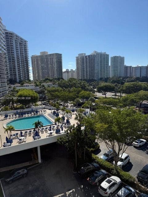 3701 N Country Club Drive, #706, Aventura, FL 33180 Elevated outdoor swimming pool featuring a paved deck and mature palm trees, set against an urban landscape