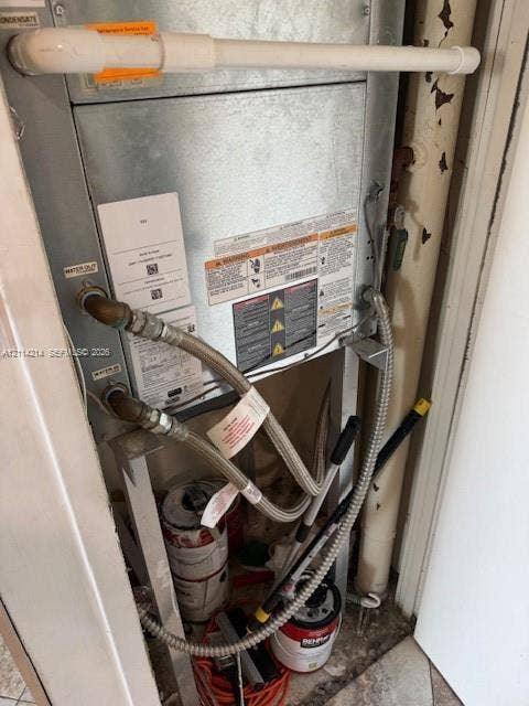 3701 N Country Club Drive, #706, Aventura, FL 33180 Metal HVAC air handler unit featuring a metallic casing, reinforced braided water supply lines, and external condensate drainage piping