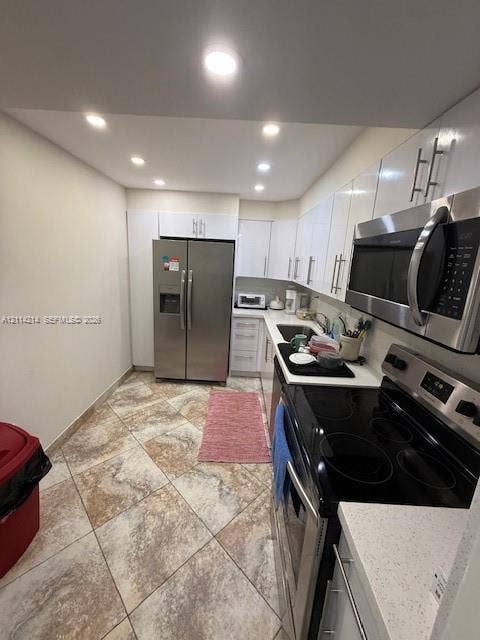 3701 N Country Club Drive, #706, Aventura, FL 33180 Kitchen featuring white cabinetry, stone-finish countertops, stainless steel appliances, and tile flooring