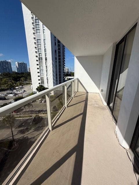 3701 N Country Club Drive, #706, Aventura, FL 33180 Private balcony featuring a glass-panel railing, concrete flooring, and a covered ceiling