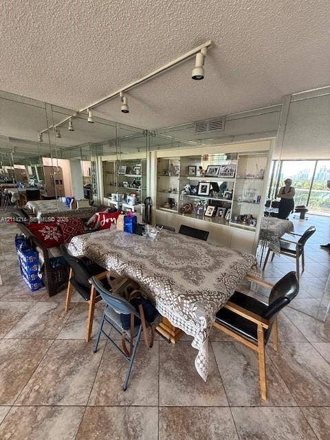 3701 N Country Club Drive, #706, Aventura, FL 33180 Floor-to-ceiling mirrored walls, built-in display cabinetry with glass shelving, tile flooring, and adjustable track lighting
