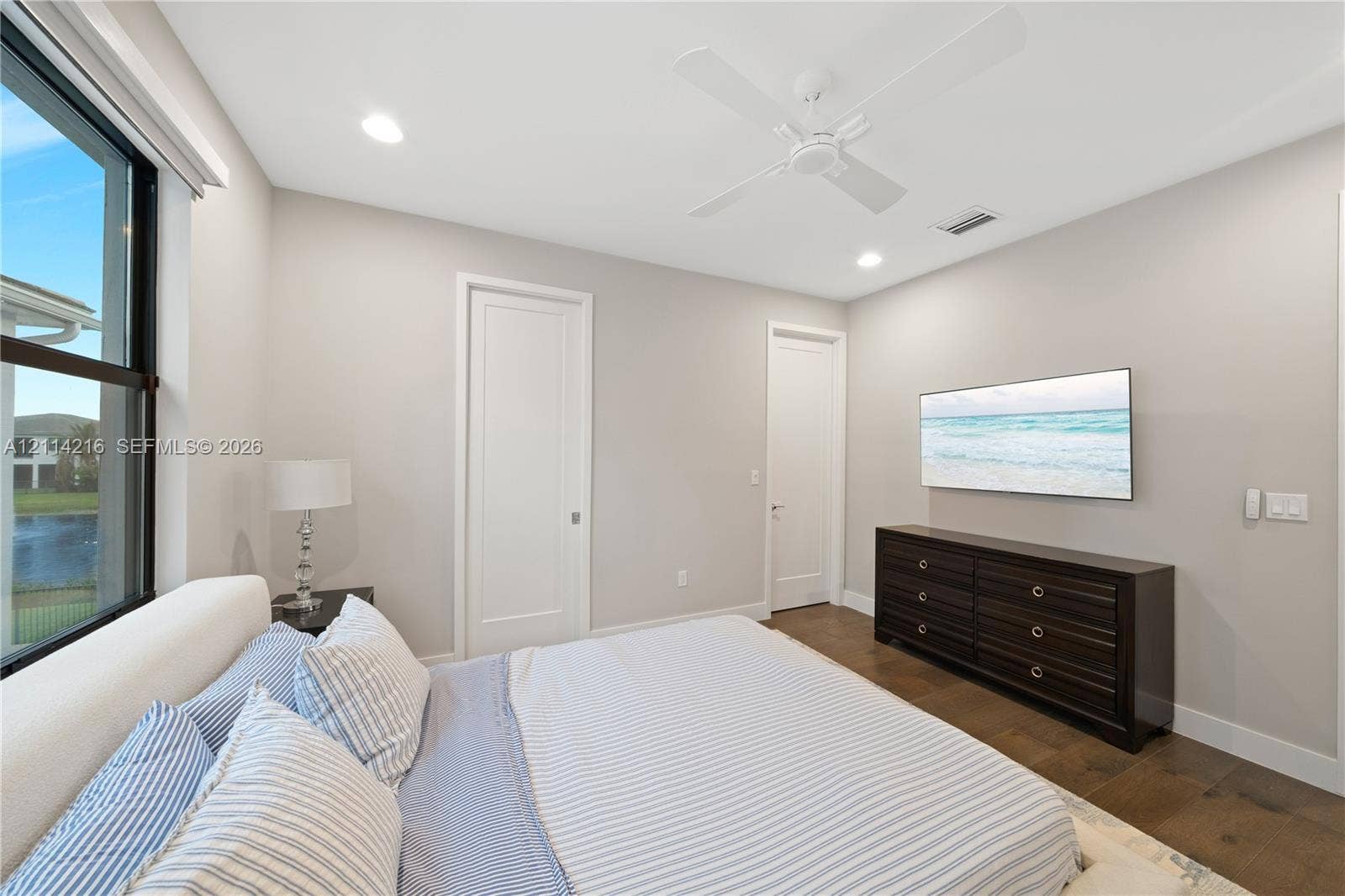 17085 Teton River Road, Boca Raton, FL 33496 Neutral-toned interior featuring floor-to-ceiling windows, wood-finish flooring, a ceiling fan with integrated lighting, and solid-core doors