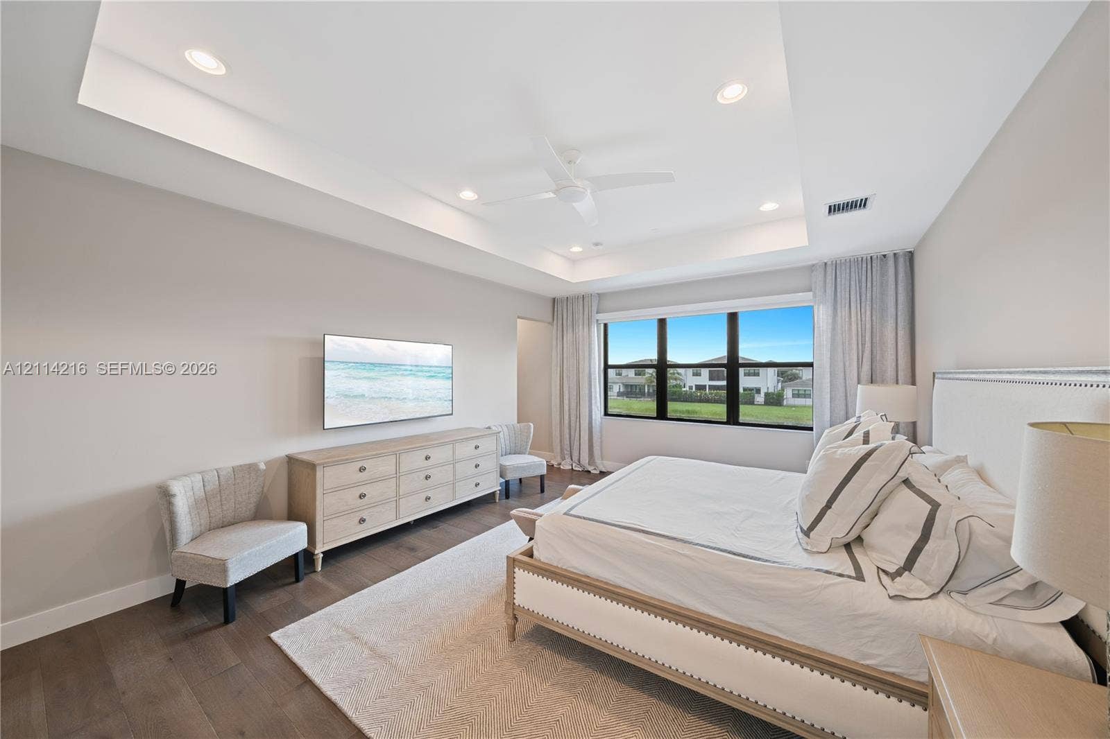 17085 Teton River Road, Boca Raton, FL 33496 Tray ceiling with integrated recessed lighting, ceiling fan, wood-finish flooring, and multi-pane window